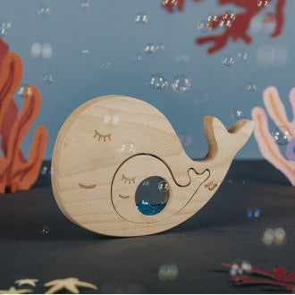 Wooden snail toy with coral and starfish on a dark blue background